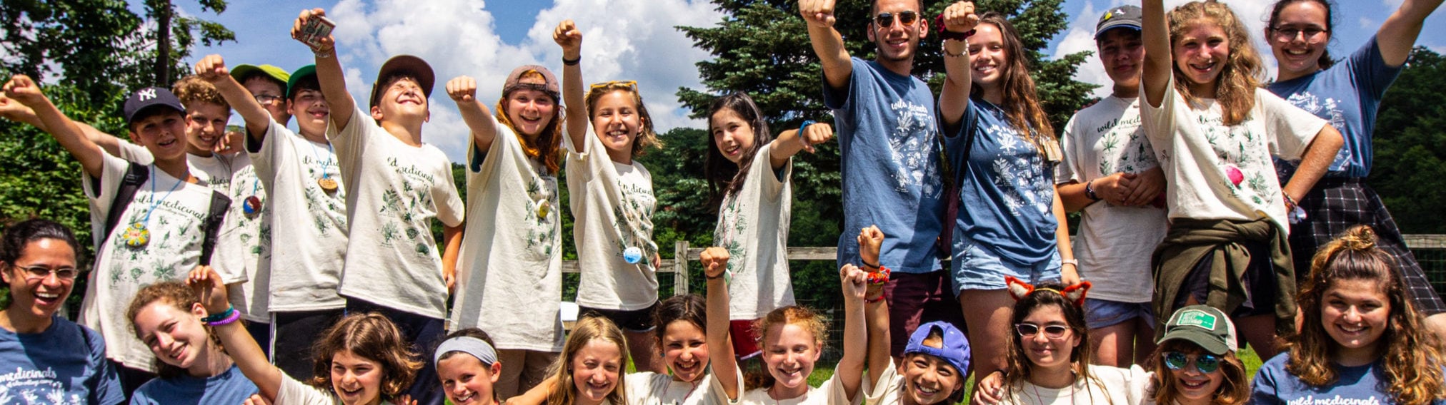 Group of cheerful children and teenagers posing outdoors, celebrating together.